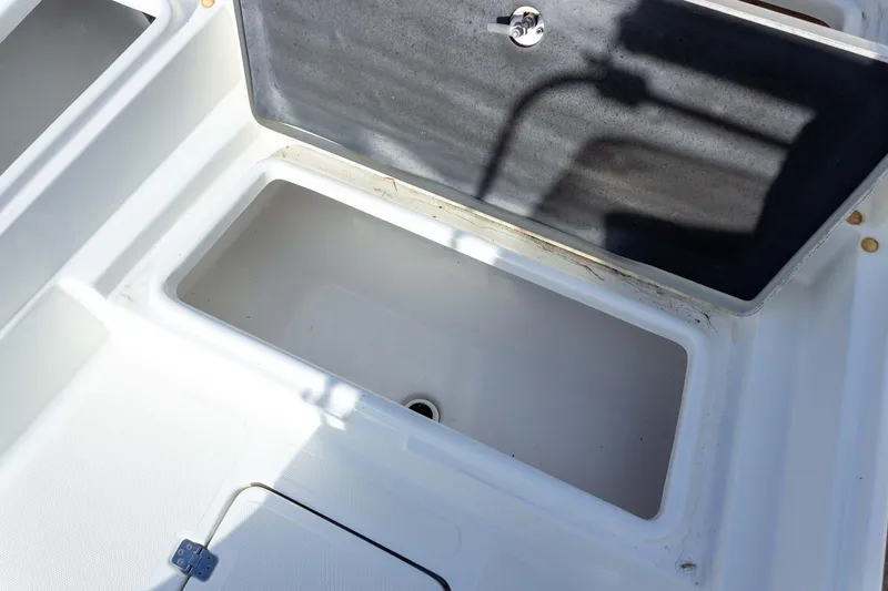 Slide: The Image of Open storage compartment on a 2014 NauticStar 2400 Sport boat. - 15