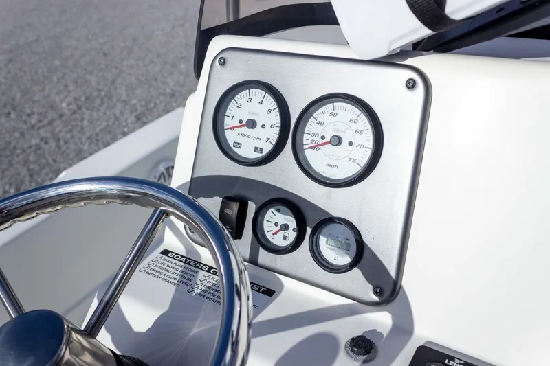 Slide: The Image of Dashboard of 2014 NauticStar 2400 Sport boat with gauges and steering wheel. - 22