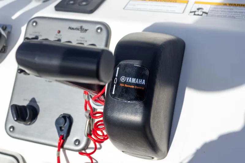 Slide: The Image of Yamaha 704 remote control on 2014 NauticStar 2400 Sport boat dashboard. - 25