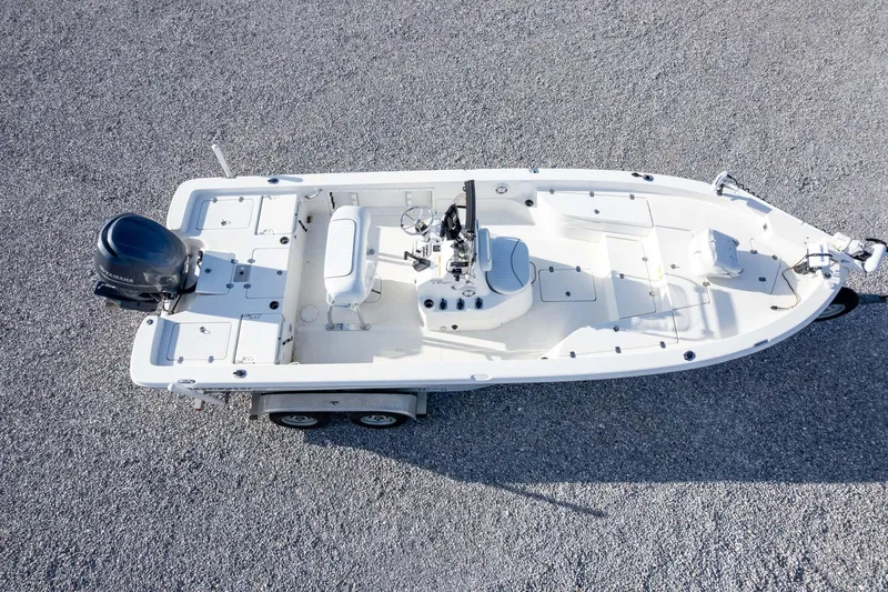 Slide: The Image of 2014 NauticStar 2400 Sport boat on trailer, aerial view, parked on gravel surface. - 39