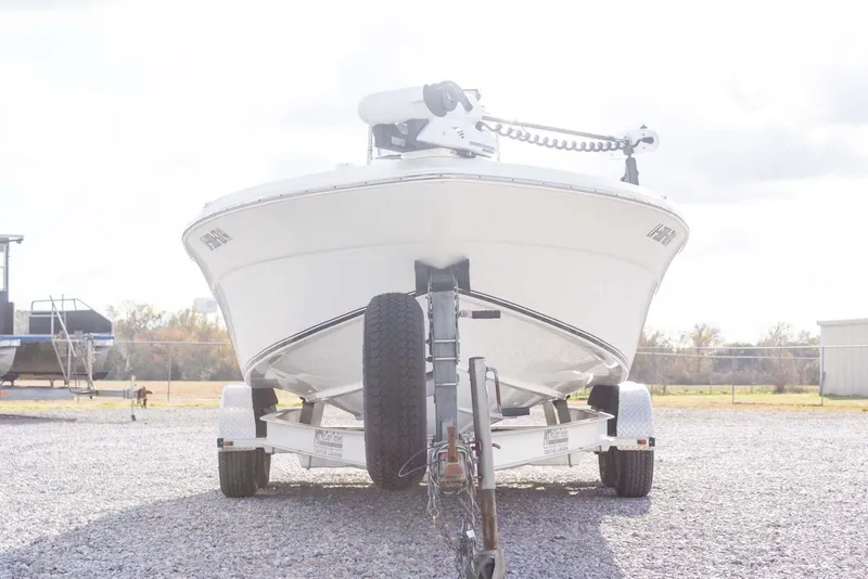 Slide: The Image of 2014 NauticStar 2400 Sport boat on trailer, parked on gravel lot. - 5