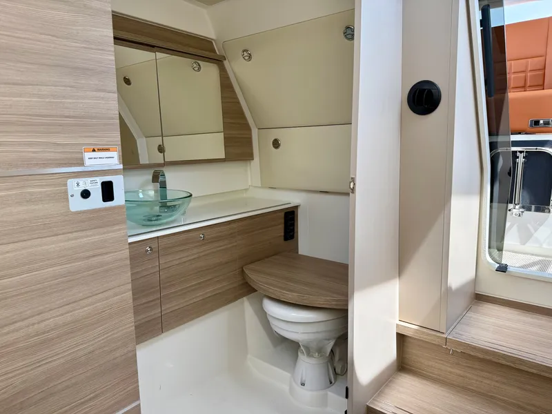 Slide: The Image of The image shows a modern boat bathroom with wood paneling and a glass sink. - 14