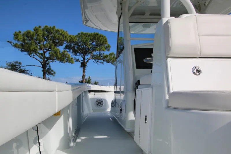Slide: The Image of 2022 Yellowfin 39 Offshore boat interior with white seating and clear blue sky. - 15