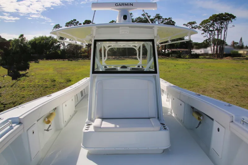 Slide: The Image of 2022 Yellowfin 39 Offshore boat with spacious deck and seating, set in a grassy area. - 22