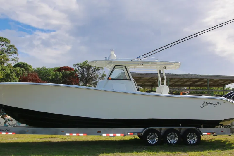 Slide: The Image of 2022 Yellowfin 39 Offshore boat on trailer, set against a scenic outdoor backdrop. - 24