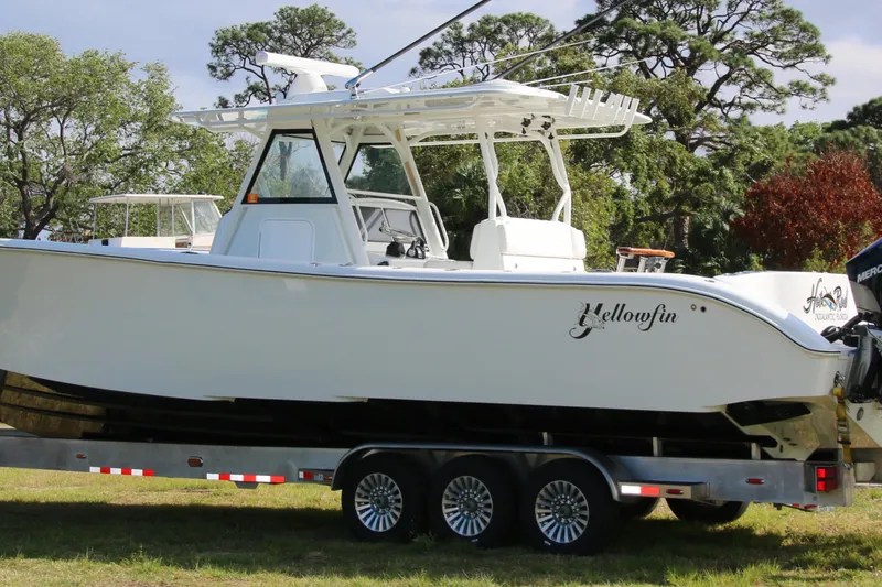Slide: The Image of 2022 Yellowfin 39 Offshore boat on trailer, surrounded by trees. - 27