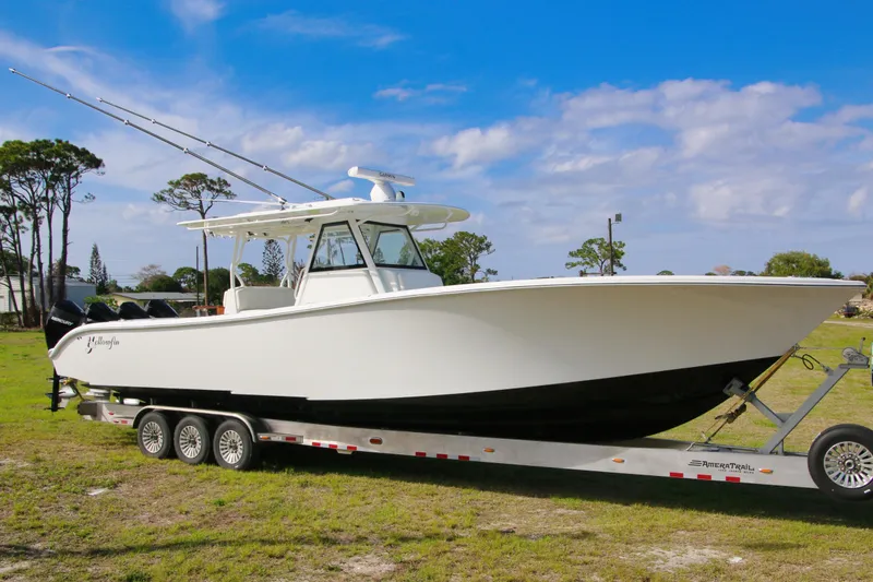 Slide: The Image of 2022 Yellowfin 39 Offshore boat on trailer, parked on grass under blue sky. - 32