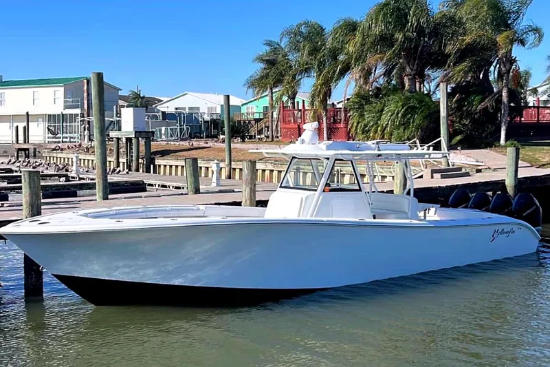 Slide: The Image of 2022 Yellowfin 39 Offshore boat docked near palm trees and waterfront homes. - 5