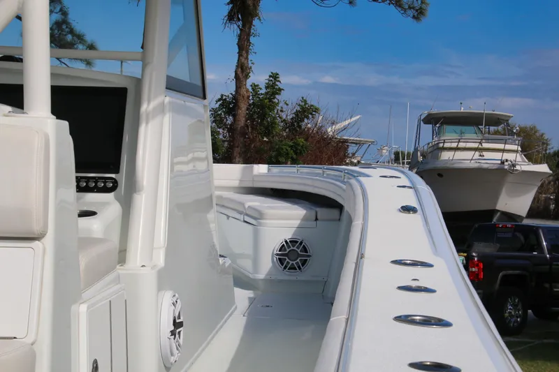 Slide: The Image of 2022 Yellowfin 39 Offshore boat interior with seating and control panel, docked near other vessels. - 6