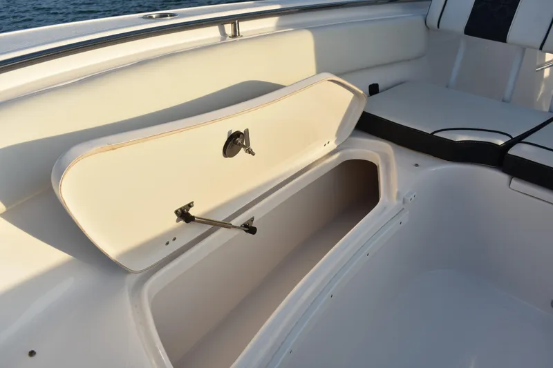 Slide: The Image of 2021 Tidewater 232 LXF boat storage compartment with open hatch, white interior. - 14