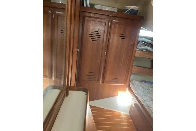 Slide: The Image of Interior of 1995 Hunter Legend 40.5 sailboat with wooden cabinetry and bunk beds. - 14