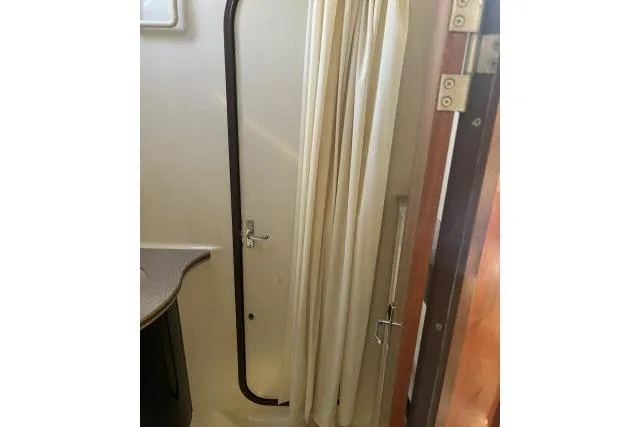 Slide: The Image of Interior of 1995 Hunter Legend 40.5 sailboat showing bathroom door and curtain. - 17