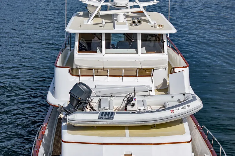 Slide: The Image of 1970 Hargrave Yachtfisher with dinghy on deck, cruising on calm waters. - 10
