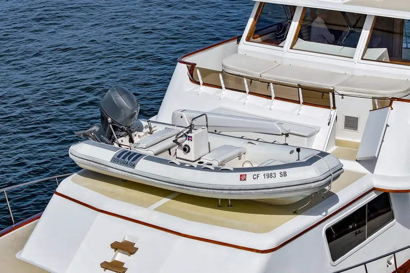 Slide: The Image of 1970 Hargrave Yachtfisher with inflatable boat on deck, cruising on calm waters. - 11