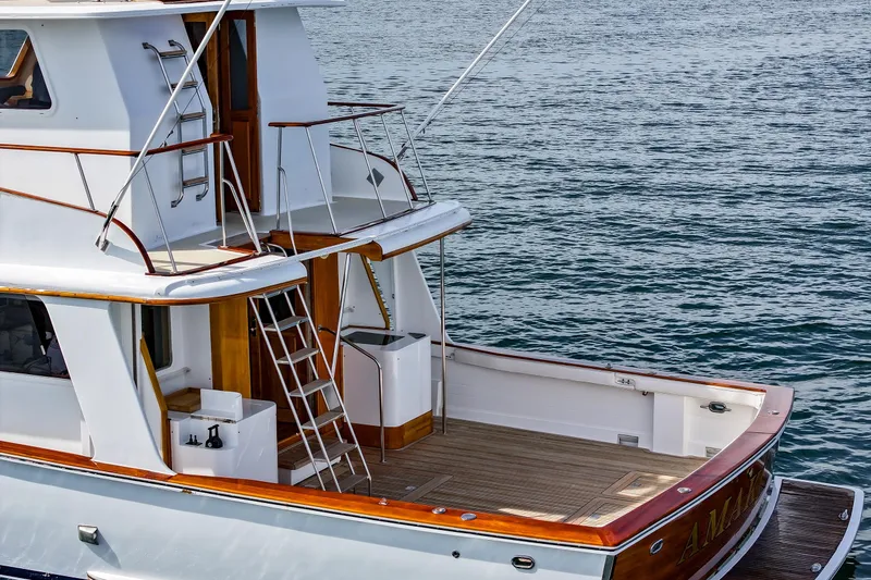 Slide: The Image of 1970 Hargrave Yachtfisher with wooden deck, docked on calm water. - 12