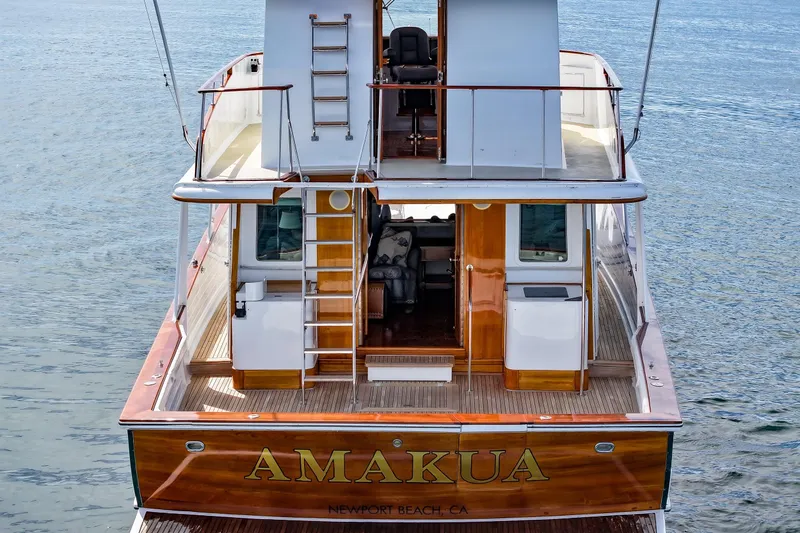 Slide: The Image of 1970 Hargrave Yachtfisher "AMAKUA" docked at Newport Beach, featuring elegant wooden deck. - 13