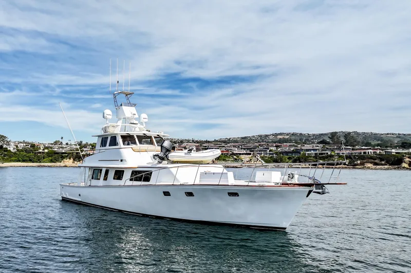 Slide: The Image of 1970 Hargrave Yachtfisher on calm water with scenic coastal background. - 3