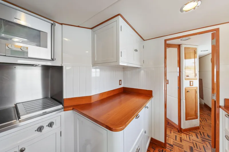 Slide: The Image of 1970 Hargrave Yachtfisher kitchen with wood countertops and white cabinetry. - 34
