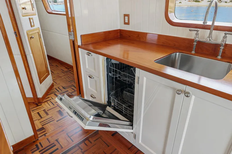 Slide: The Image of 1970 Hargrave Yachtfisher kitchen with open dishwasher, wooden countertops, and stainless steel sink. - 36