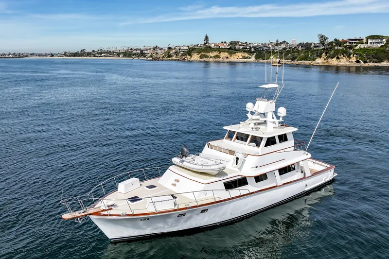 Slide: The Image of 1970 Hargrave Yachtfisher cruising near scenic coastline under clear blue sky. - 5