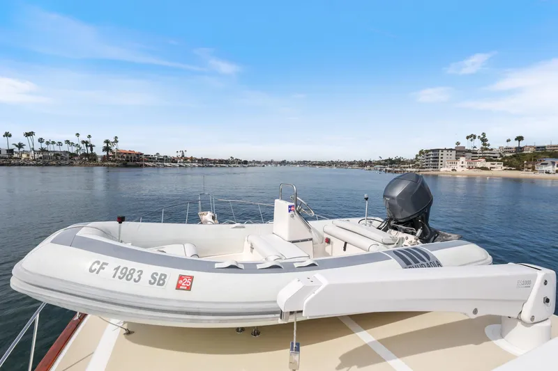 Slide: The Image of 1970 Hargrave Yachtfisher with inflatable boat on deck, overlooking serene coastal waters. - 64