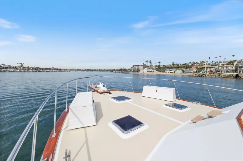 Slide: The Image of 1970 Hargrave Yachtfisher cruising on calm waters near coastal homes under a clear blue sky. - 67