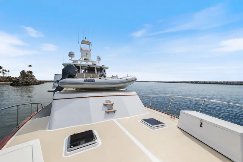 Slide: The Image of 1970 Hargrave Yachtfisher on calm waters with inflatable boat on deck. - 70