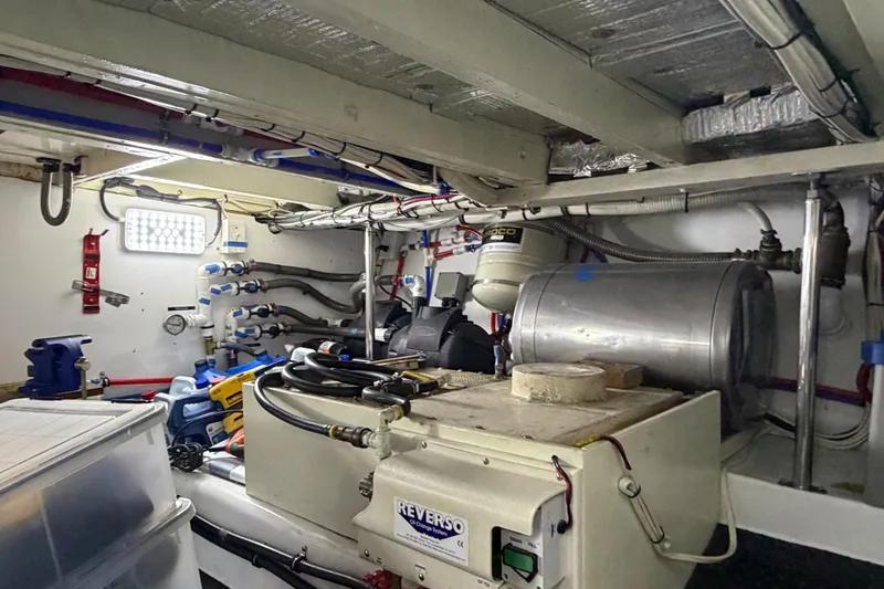 Slide: The Image of Engine room of a 1970 Hargrave Yachtfisher, showcasing mechanical equipment and piping. - 76