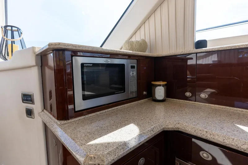 Slide: The Image of Luxurious kitchen area on 2008 Sea Ray 520 Sedan Bridge yacht with microwave and cabinets. - 17