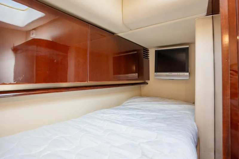 Slide: The Image of 2008 Sea Ray 520 Sedan Bridge cabin with bed, TV, and wooden cabinets. - 27