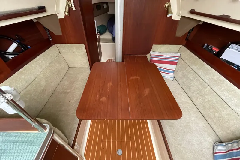 Slide: The Image of 1985 Canadian Sailcraft CS 30 interior with wooden table and cushioned seating. - 17