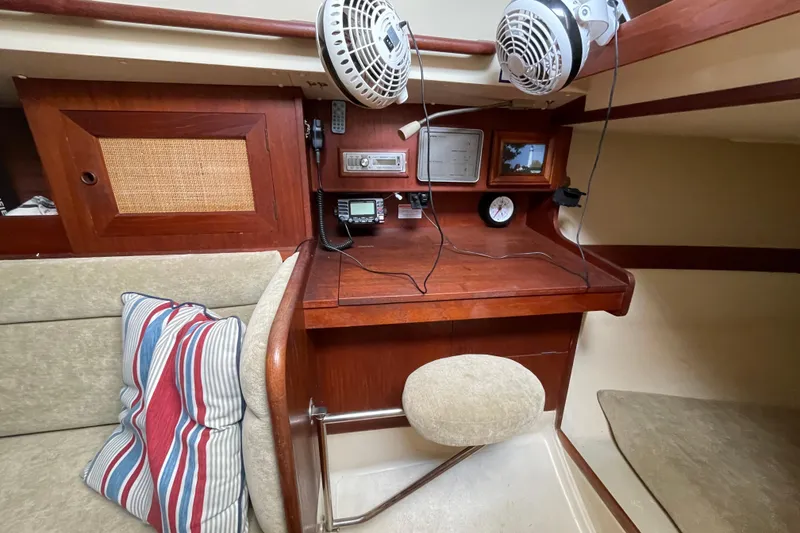 Slide: The Image of 1985 Canadian Sailcraft CS 30 interior with navigation station and striped cushions. - 19