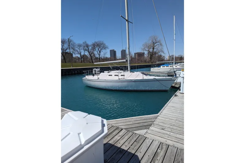 Slide: The Image of 1985 Canadian Sailcraft CS 30 sailboat docked in a marina with clear blue water. - 2