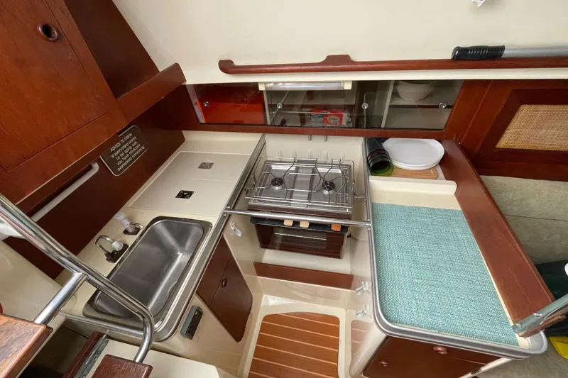 Slide: The Image of Compact galley kitchen in 1985 Canadian Sailcraft CS 30 sailboat, featuring stove and sink. - 26