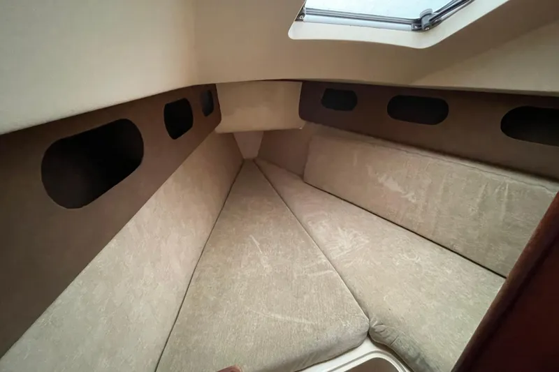 Slide: The Image of 1985 Canadian Sailcraft CS 30 interior cabin with beige cushions and portholes. - 27