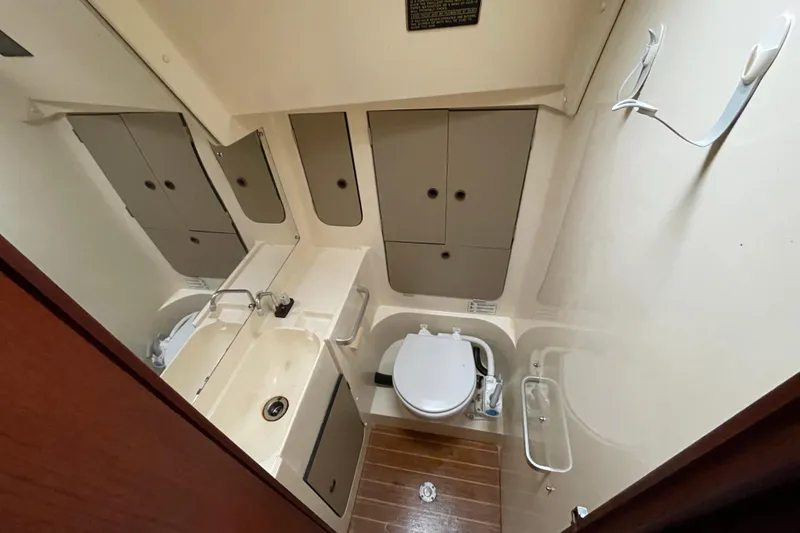 Slide: The Image of 1985 Canadian Sailcraft CS 30 yacht bathroom with sink, toilet, and storage cabinets. - 29