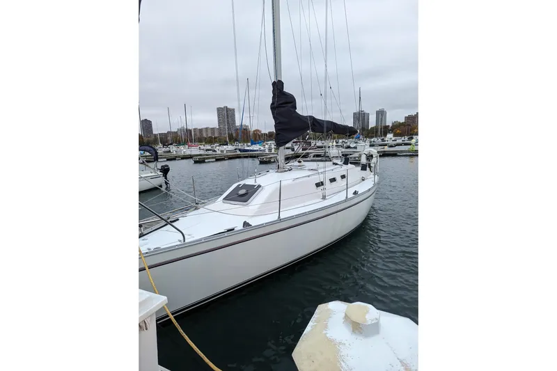 Slide: The Image of 1985 Canadian Sailcraft CS 30 sailboat docked in a marina with cityscape background. - 5