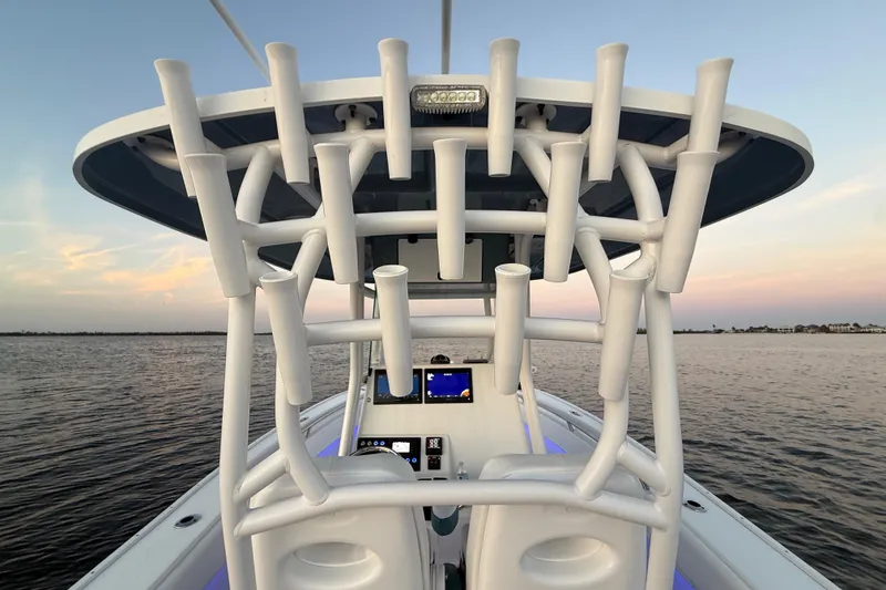 Slide: The Image of 2019 Cape Horn 27 boat console with rod holders at sunset on calm water. - 32