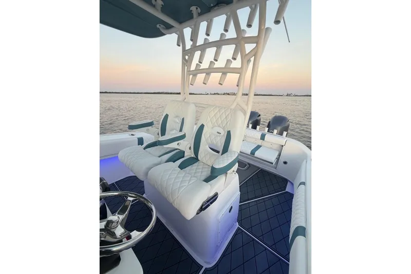 Slide: The Image of 2019 Cape Horn 27 boat interior with plush seating and rod holders at sunset. - 24