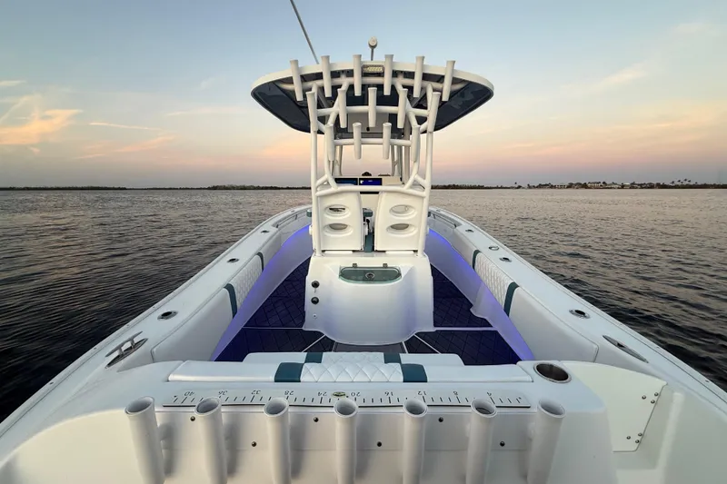 Slide: The Image of 2019 Cape Horn 27 boat on calm water at sunset, featuring spacious deck and rod holders. - 26
