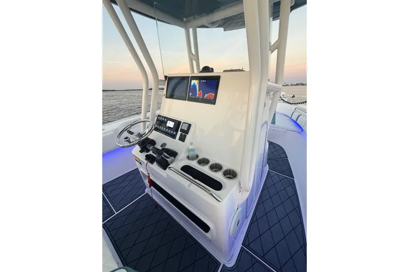 Slide: The Image of 2019 Cape Horn 27 boat console with steering wheel and navigation display at sunset. - 28