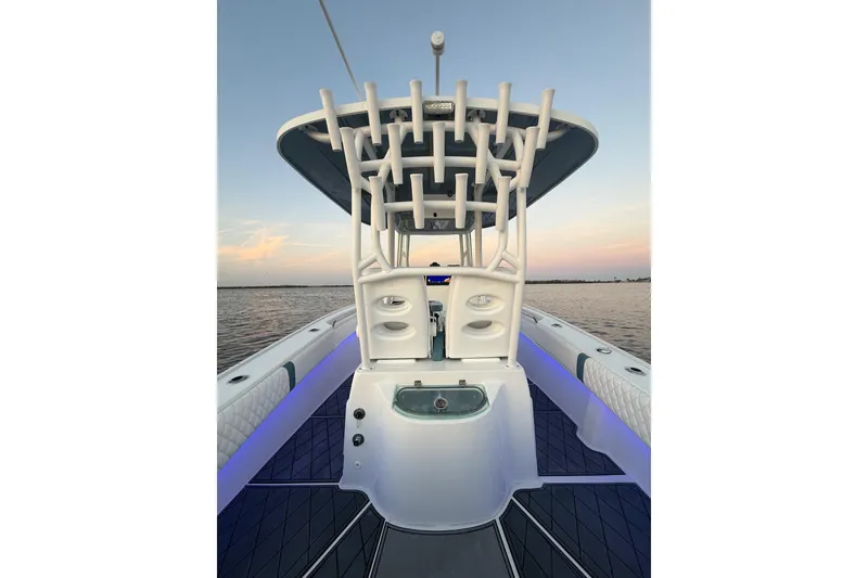 Slide: The Image of 2019 Cape Horn 27 boat interior with rod holders, sleek design, and ocean backdrop at sunset. - 31