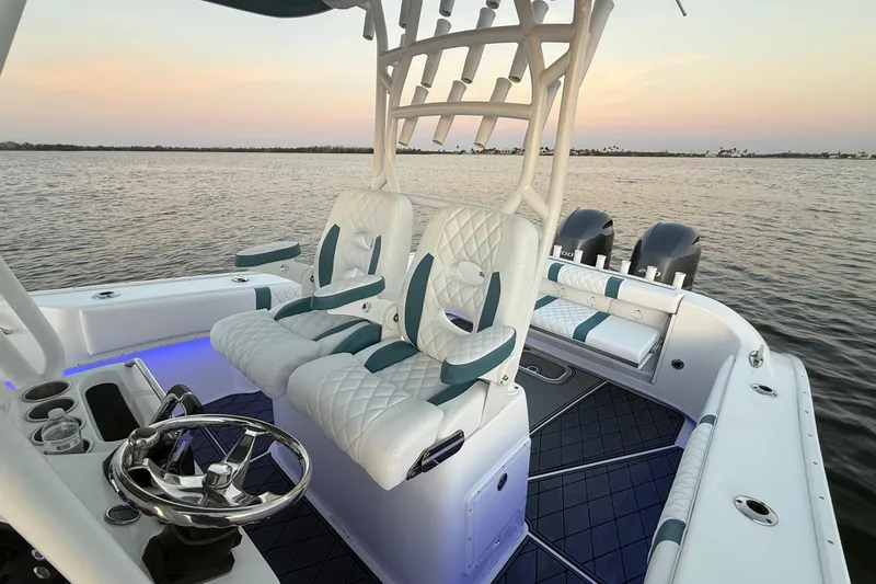 Slide: The Image of 2019 Cape Horn 27 boat interior with plush seating and dual engines at sunset. - 5