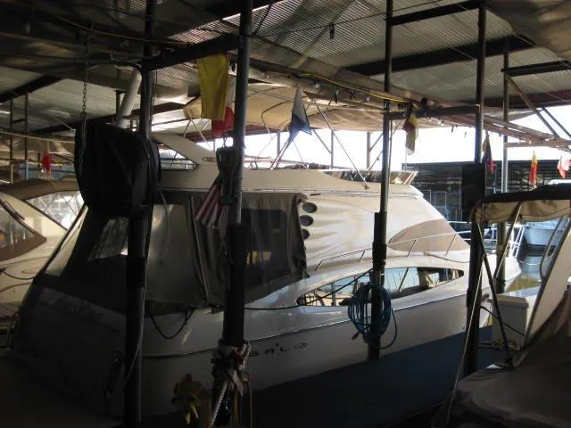 The Image of 2001 Regal Commodore 3880 yacht docked in a covered marina, side view. - 0