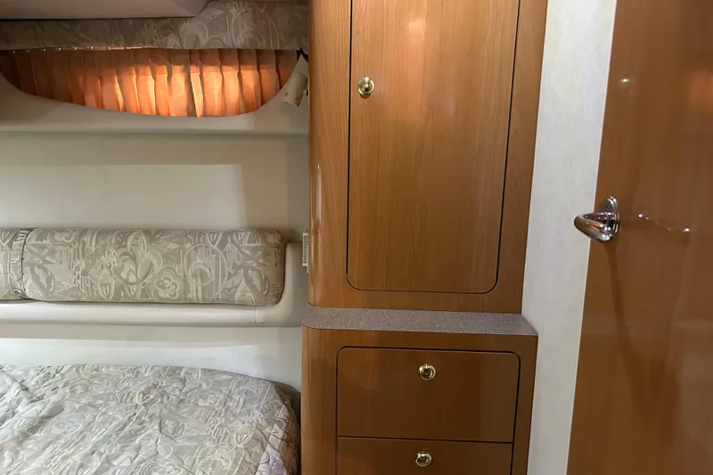 Slide: The Image of Interior of 2001 Regal Commodore 3880 yacht with wooden cabinets and patterned bedding. - 23