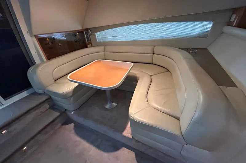 Slide: The Image of 2001 Regal Commodore 3880 yacht interior with beige leather seating and wooden table. - 31