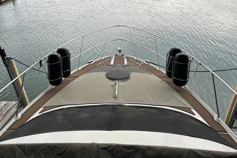 Slide: The Image of 2001 Regal Commodore 3880 yacht bow view, docked on calm water. - 32