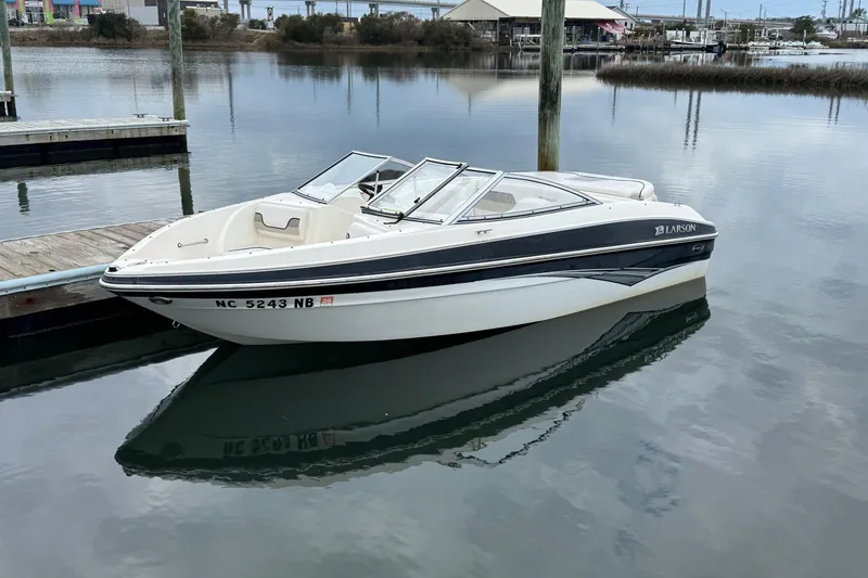 Slide: The Image of 2010 Larson LX 1750 boat docked on calm water. - 4