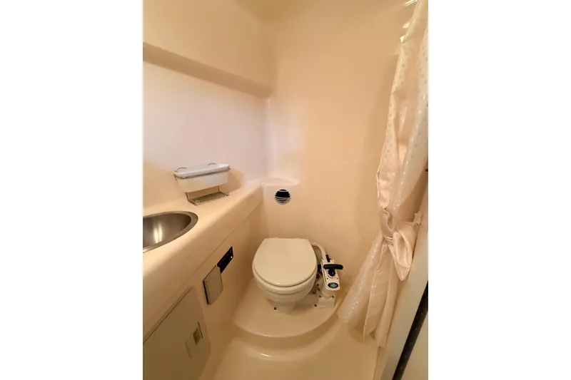 Slide: The Image of 2007 Glastron GS 279 boat bathroom with toilet, sink, and shower curtain. - 17