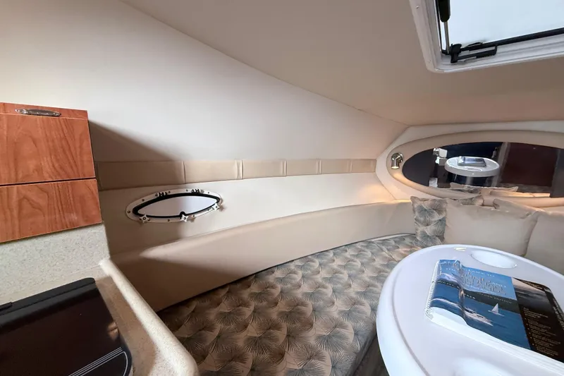 Slide: The Image of 2007 Glastron GS 279 cabin interior with seating, table, and porthole window. - 19